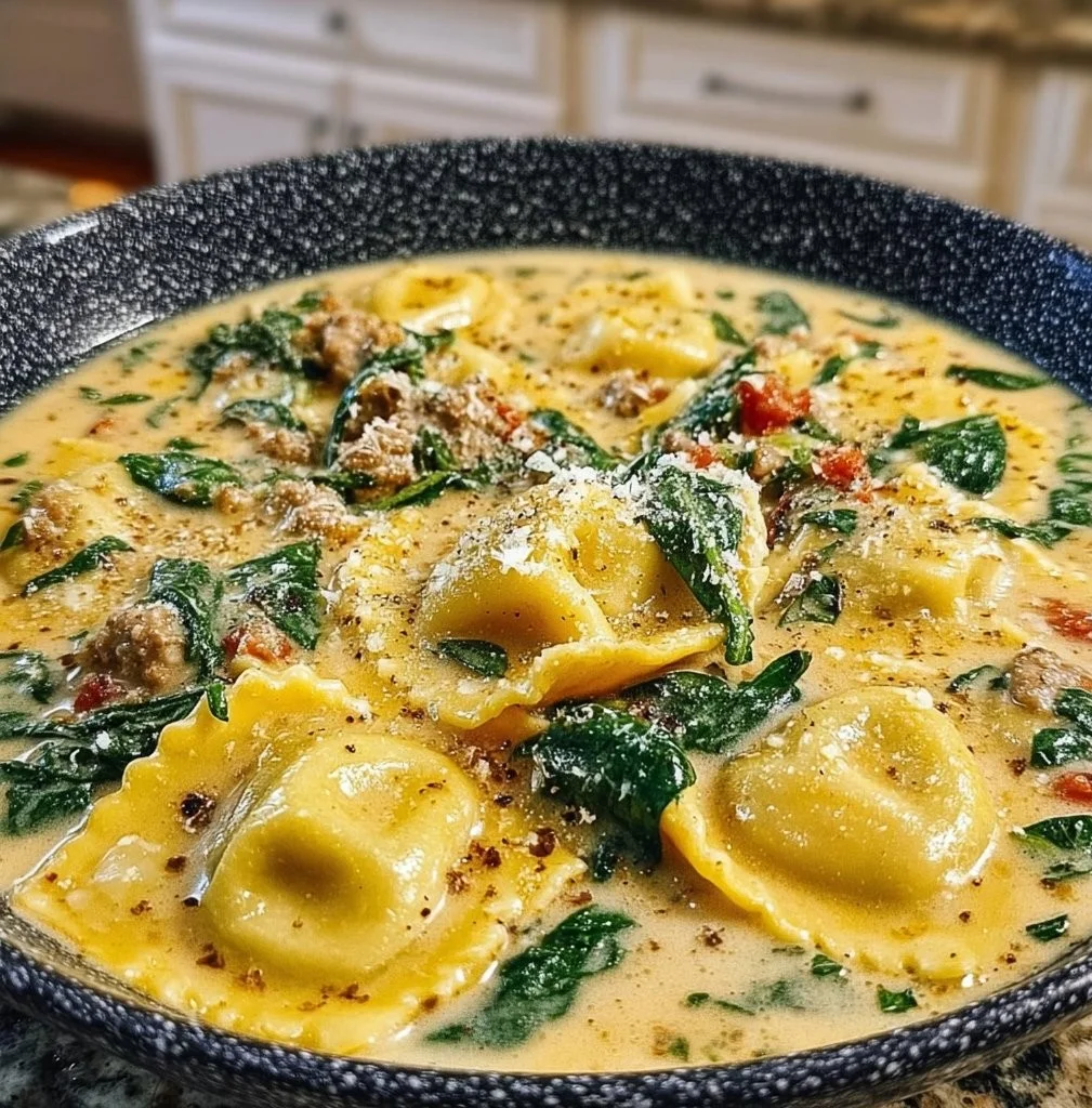 Creamy one pot ravioli soup served in a bowl with fresh herbs.